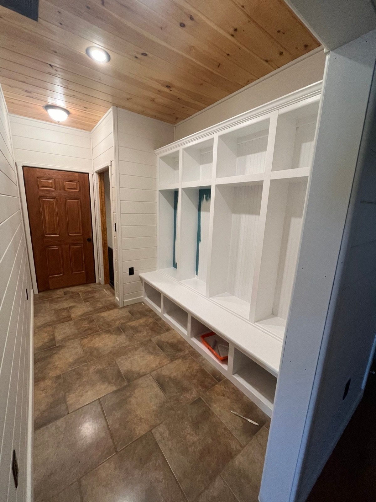 Mudroom lockers being repainted white with teal going into the beadboard backs, in a North Georgia cabin